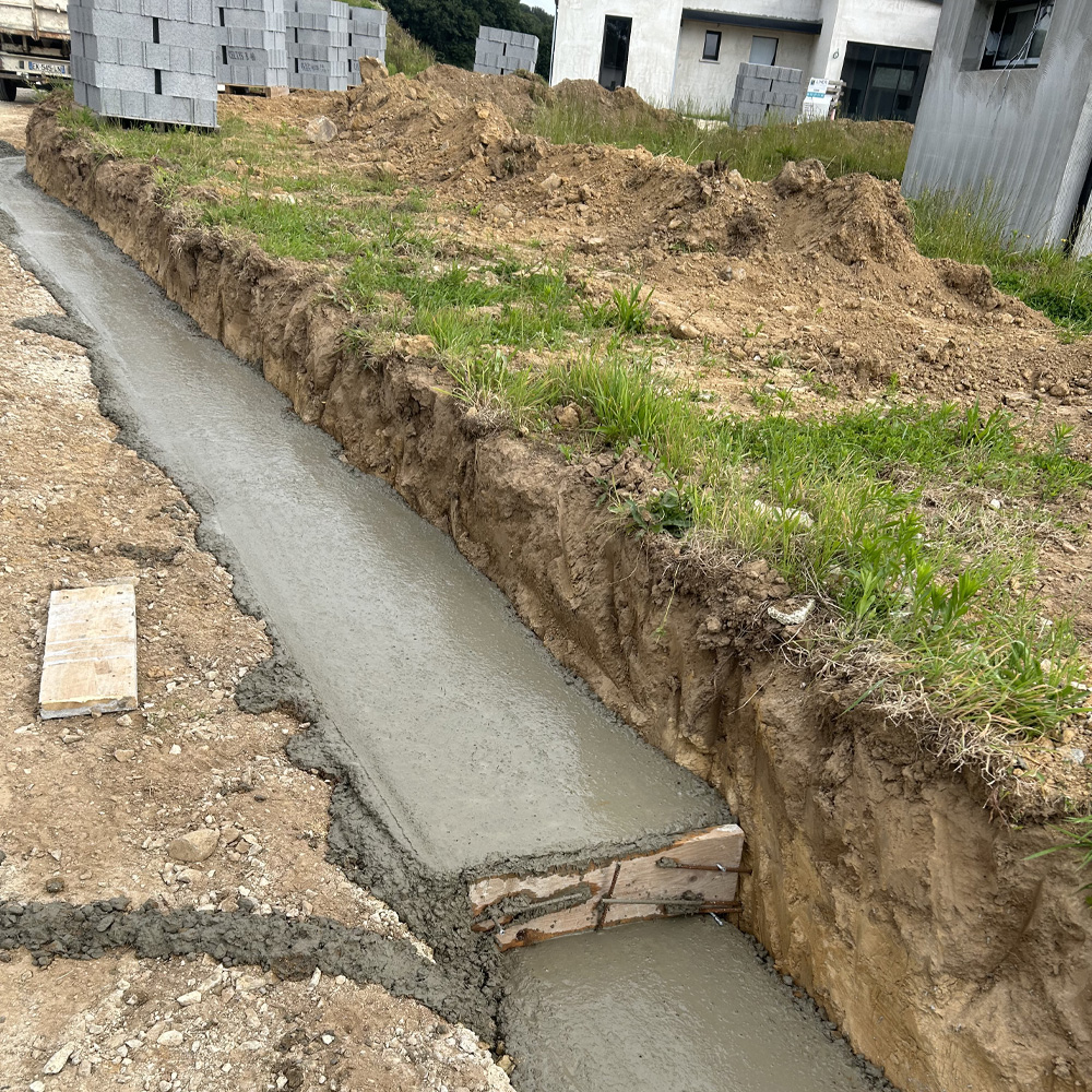 Terrassement, fondation pour mur de clôture en parpaing. Création de niveaux. Détail